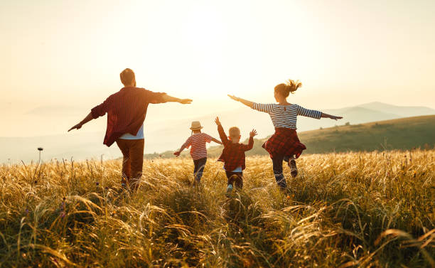 A family walking together through a golden field at sunset