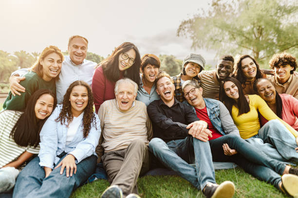 A multigenerational group gathered together outdoors, smiling